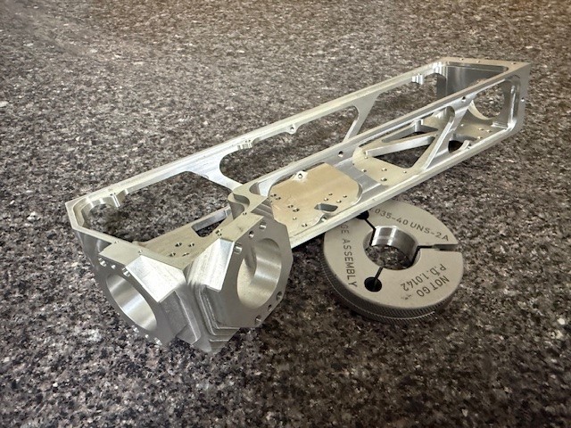 CNC-machined aluminum chassis frame with complex geometry and thread gauge verification